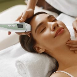 Skin Care. Women Analyzing Facial Skin With Analyzer. Beauty Skin Care. Beautiful Healthy Woman Getting Her Skin Analized By Cosmetologist, Using Skin Analyzer ( Professional Beauty Equipment ) For Face Skin Analysis At Cosmetology Center. High Resolution Image